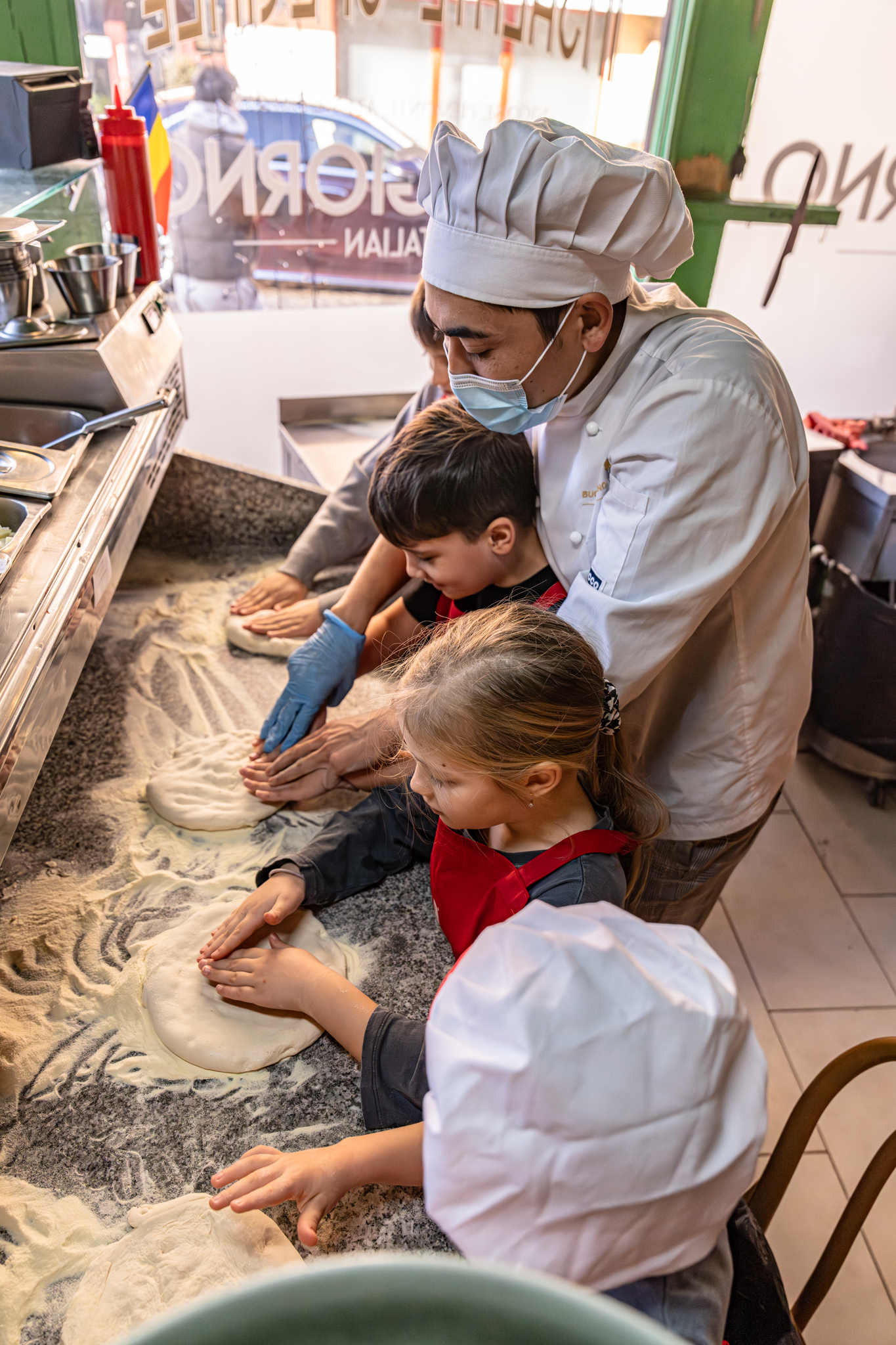 copii frământând aluatul la un atelier de pizza organizat de Worknest în București