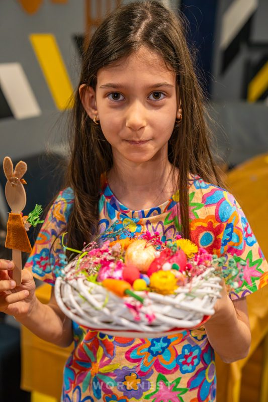 copil decorând o coroniță de Paște la un atelier creativ Worknest