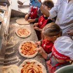 copiii învață să prepare pizza la un atelier de gătit organizat de Worknest în București