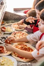 copii preparând pizza la un atelier de gătit organizat de Worknest în București