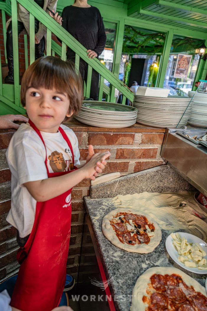 copil preparând o pizza la un atelier de gătit organizat de Worknest în București